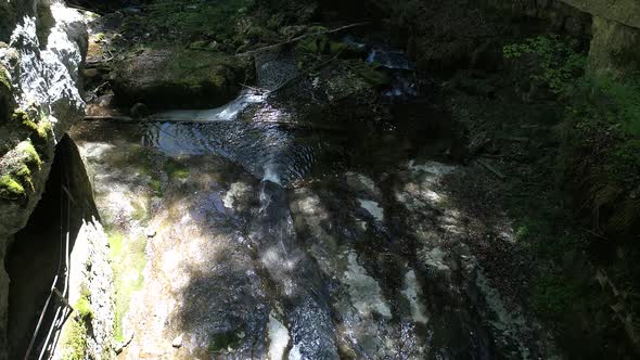 aerial shot of flying inside a cave with little stream