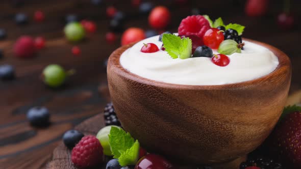 Bowl of Yogurt with Wild Berries on Wooden Table