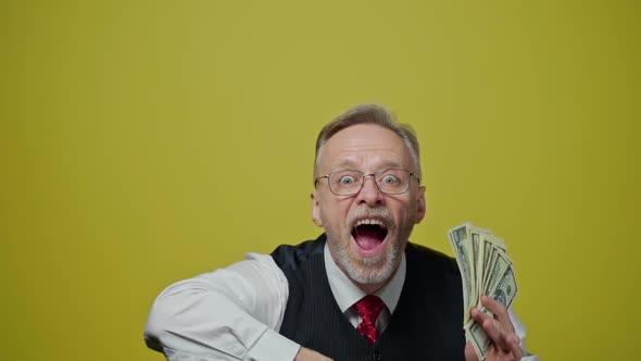 Happy elderly man throwing money