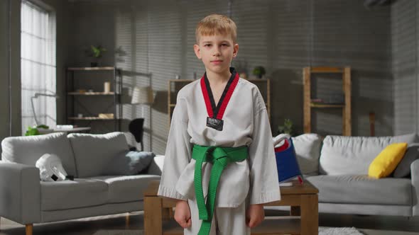 Portrait of a Karate Boy at Home Looks Into the Camera