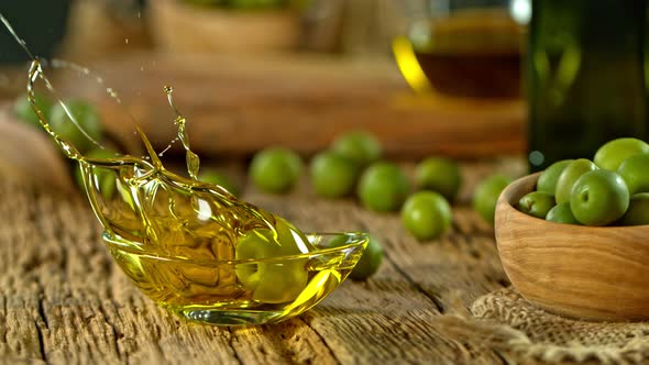 Super Slow Motion Shot of Fresh Olive Splashing Into Olive Oil at 1000 Fps.