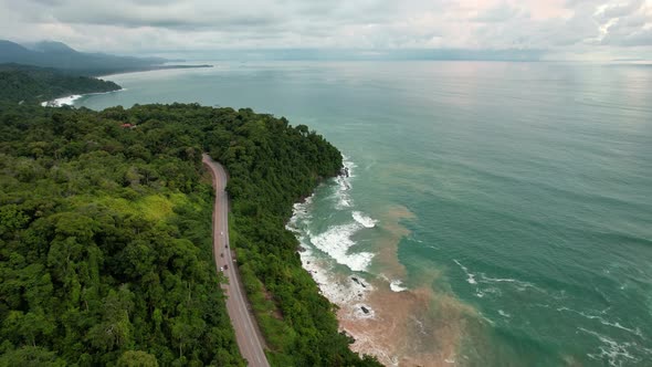 Carretera entre bosque tropical y mar de agua azul verdosa