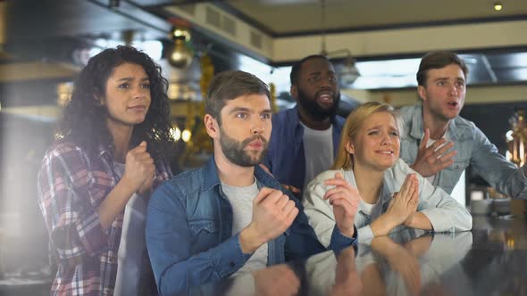 Group of Friends Watching Sports Program in Bar, Upset About Losing Game, Defeat