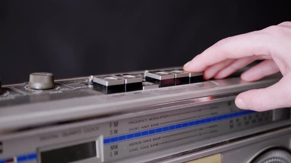 Female Fingers Pressing Buttons on an Old Vintage Tape Recorder in Dark Room