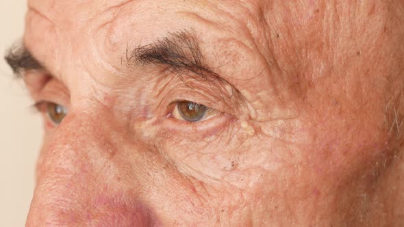 Portrait of an elderly Caucasian male over 70 who blinks frequently. Desperate and tired look of an