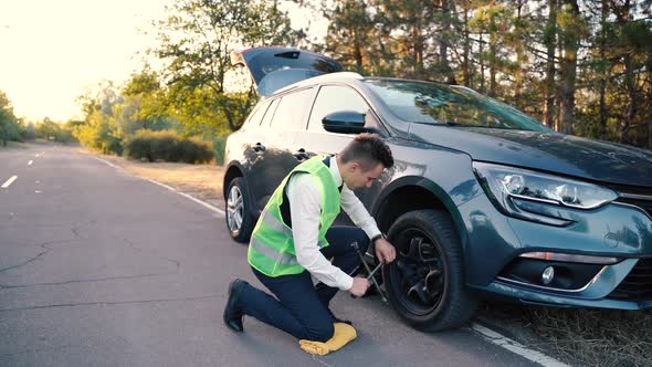 Man Changing Wheel on the Car at the Side of the Road