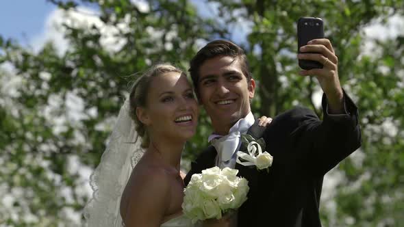 Bride and Groom Taking a Selfie Outside