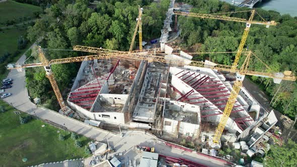 Aerial View Construction of a New Building with High Tower Cranes in Green Area