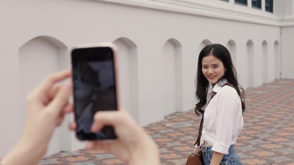 Asian lesbian couple using smartphones taking a photo.