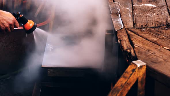 Glassblower spraying water on work bench