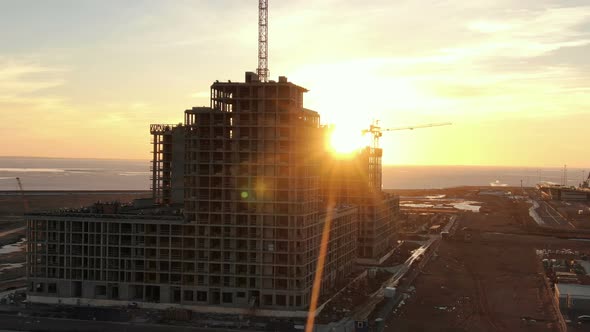 Aerial View Construction of Multi-storey Building with Construction Cranes at Sunset