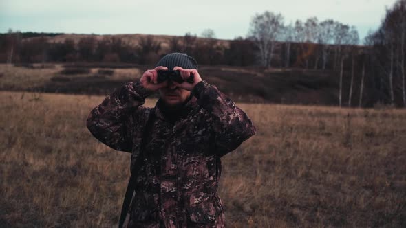 The Hunter is Looking Into the Binoculars
