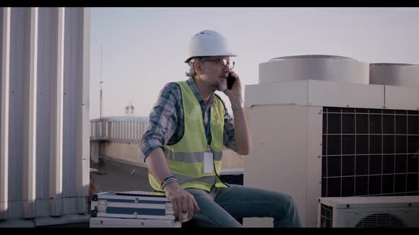 Engineer Having Phone Call on a Cell Tower