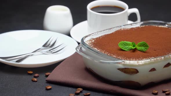 Tiramisu Dessert in Glass Baking Dish and Cup of Espresso Coffee on Concrete Background