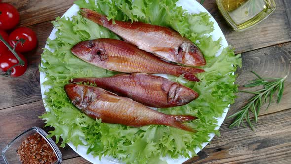 Smoked Whole Sea Fish Served Salad Leaves with Tomato and Rosemary Rotate Slowly on White Dish