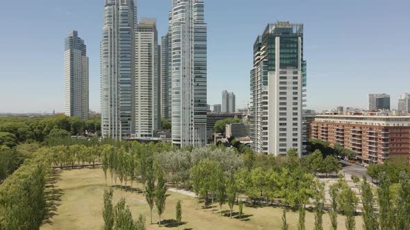 Flying Above Lush Trees Towards Contemporary Office Buildings In Puerto Madero, Buenos Aires, Argent