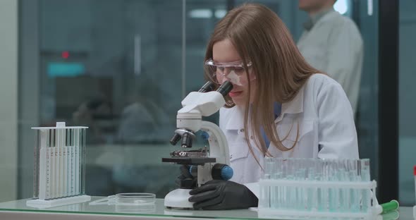 Laboratorial Tests of Vaccine and Medicaments, Female Technician Is Viewing Analysis in Microscope