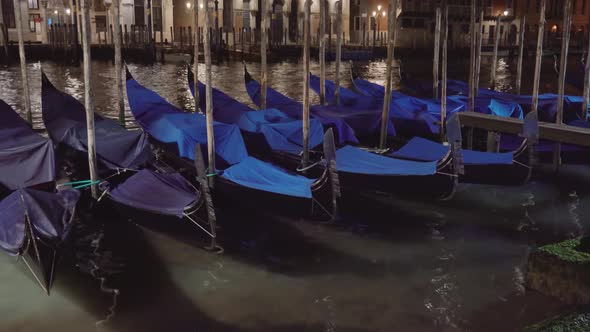 Covered Venetian Condolas Moored to Pillars Rock on Water