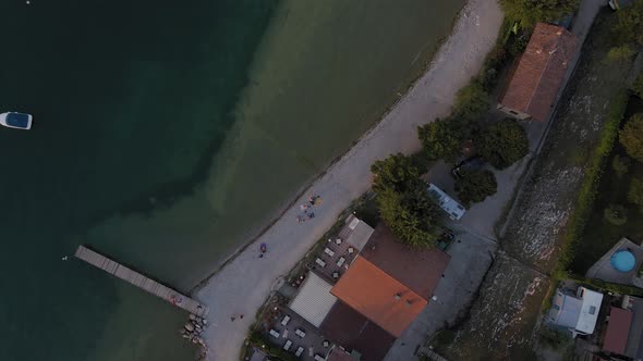 People resting on the promenade of Salo town by Lake Garda, top view aerial