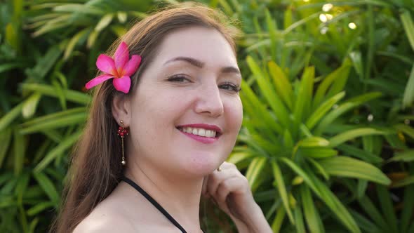 Lady with Purple Flower in Long Loose Hair Waved By Wind