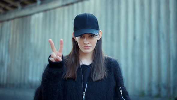 Woman Showing v Sign with Fingers Outdoors. Smiling Girl Showing Peace Sign