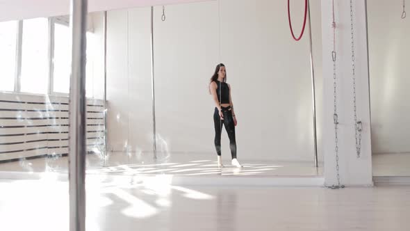 Young Woman Walks to a Ring Hanging Under the Ceiling and Looks in the Camera