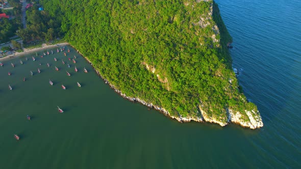 Many fishing boats on the coast beside the mountains, beautiful sea area in Thailand.