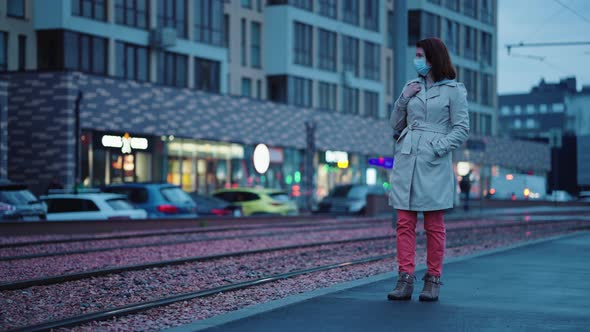 Woman in Mask Waiting for Tram