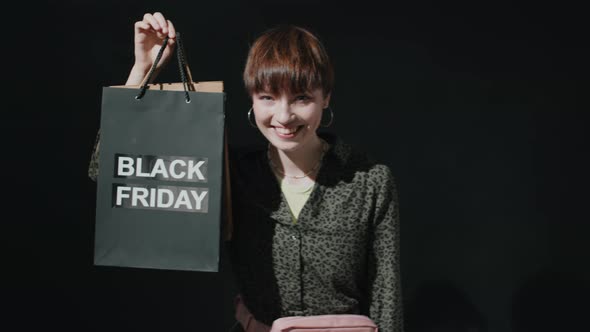 Portrait of Joyous Girl with Black Friday Shopping Bag