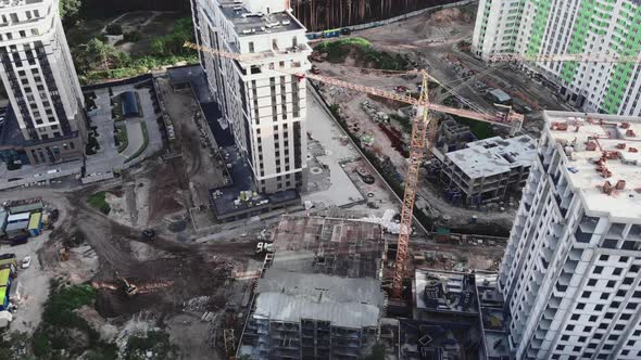 Top view of construction site with cranes and unfinished buildings in forest