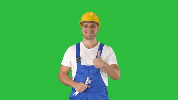 Worker with wrench showing thumb up and smiling to camera