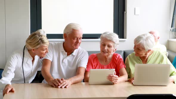 Female doctor interacting with senior citizens