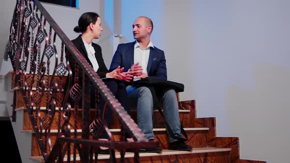 Job Partners Discussing Sitting on Stairs in Corporate Business