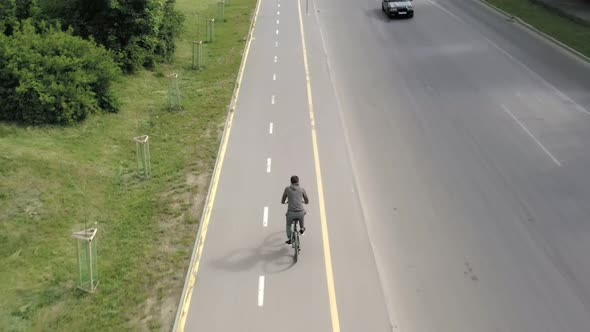 Bicycle ride on urban lane, shadow of unrecognizable cyclist riding a bike through city street