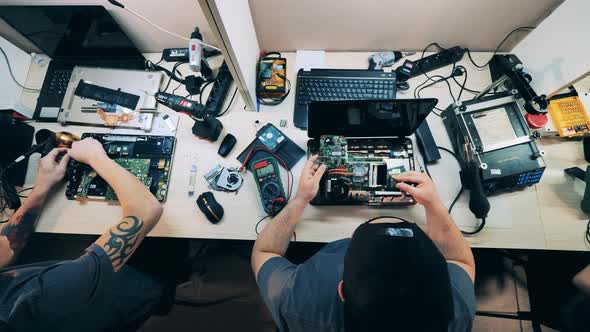 Top View Service Technicians Repairing Laptops