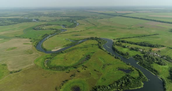 Top Down View on Exotic Winding River Seym Flows Through Green Fields