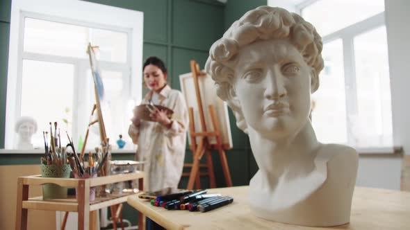 A Woman Artist Painting Standing By the Easel  Marble Bust on the Foreground