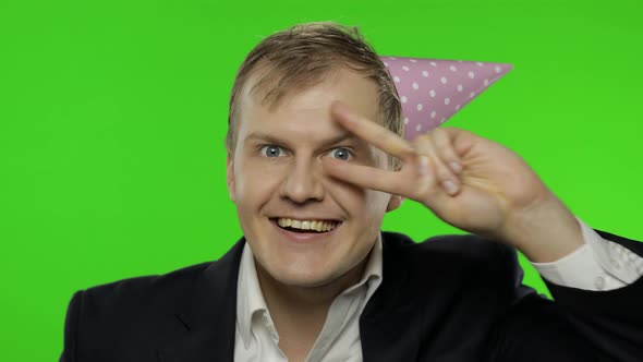 Drunk Disheveled Young Businessman in Festive Cap Celebrates and Dances