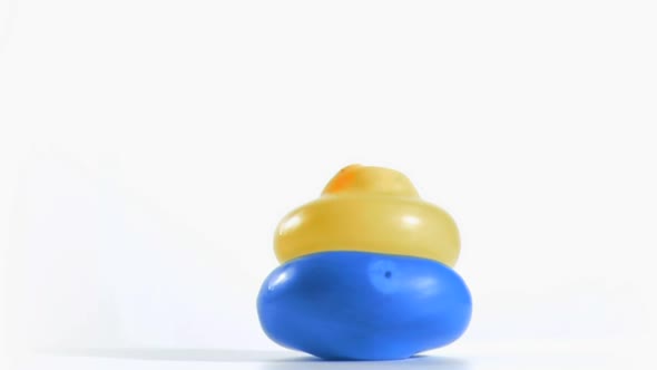 Yellow balloon rebounding in super slow motion on a blue one