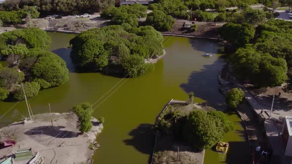 aerial tour of a small circular lake, full of trees