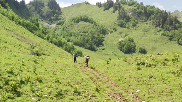 low aerial of Two hikers walking through a beautiful Swiss landscape