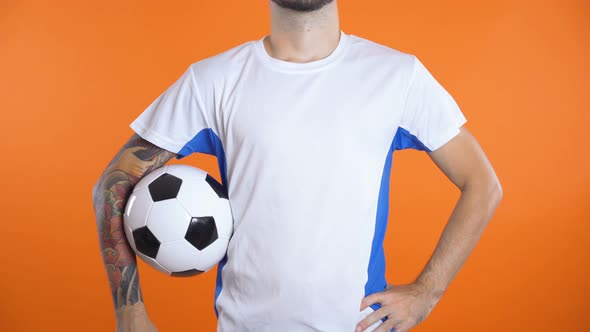 Close Up of Football Fan or Player Holding Ball Isolated on Black Background