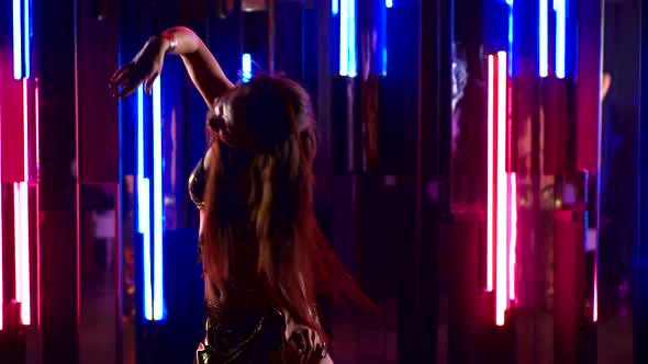 Beautiful Traditional Oriental Belly Dancer. Oriental Girl Dancing in Neon Light