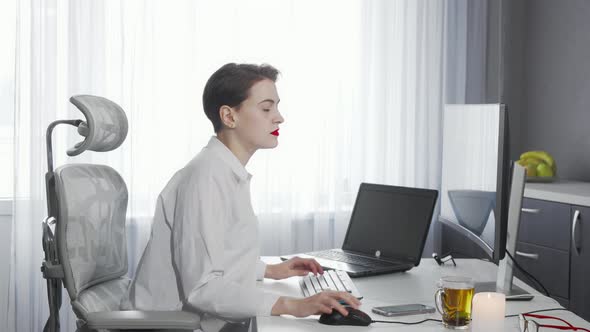 Female Freelancer Using Her Smart Phone While Working on a Computer