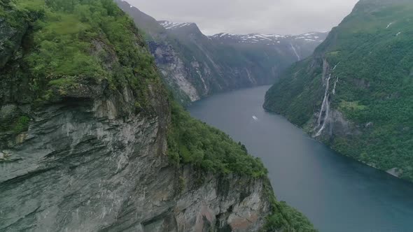 Aerial Slomo of Geiranger Fjord, Norway, flying forwards with a Moving Boat in the Background, passi