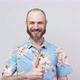 Happy bearded man wearing hawaiian shirt showing thumbs up over white background - VideoHive Item for Sale