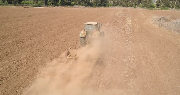 Aerial view of a tractor ploughing an empty field, Kibbutz saar, Israel.