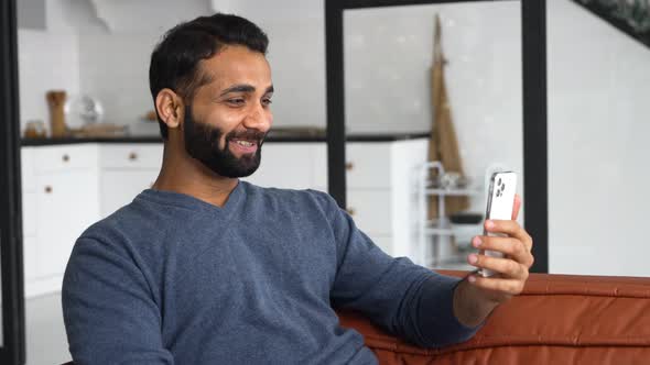 Indian Man in Casual Wear Using Smartphone App for Virtual Communication