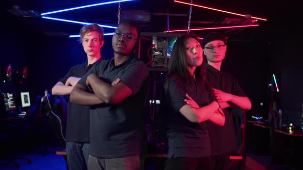The Cyber Team Consisting of Three Guys and a Girl Confidently Looks at the Camera and Folds a Arms