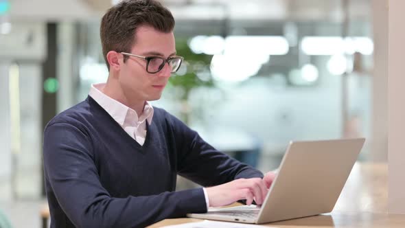 Young Businessman Working on Laptop in Office